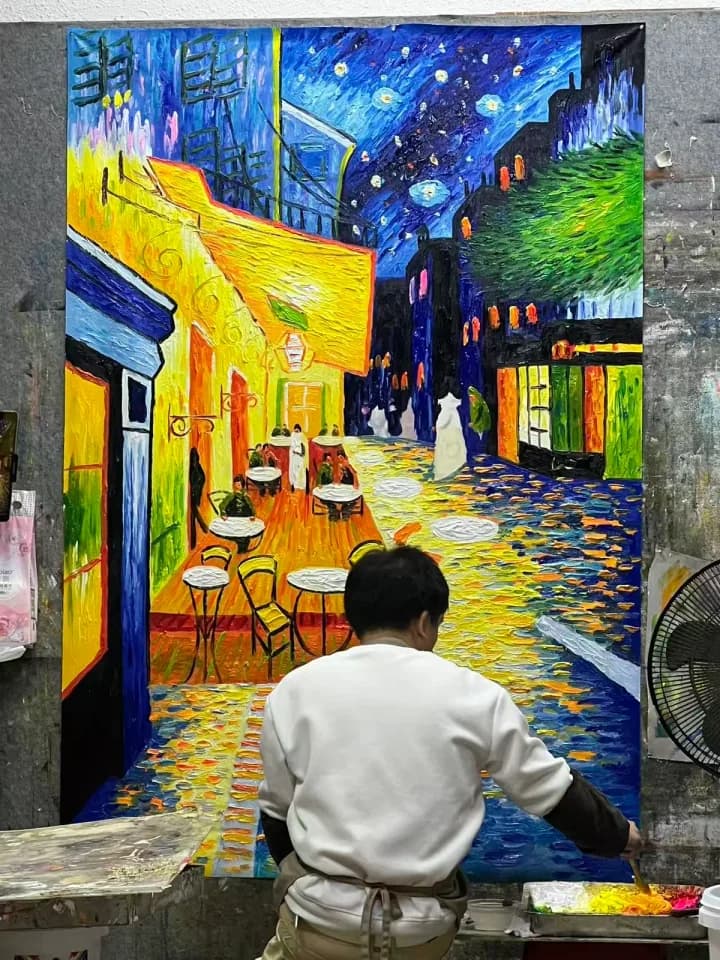 DEWANG artist hand-painting a large colorful canvas in the Shenzhen workshop