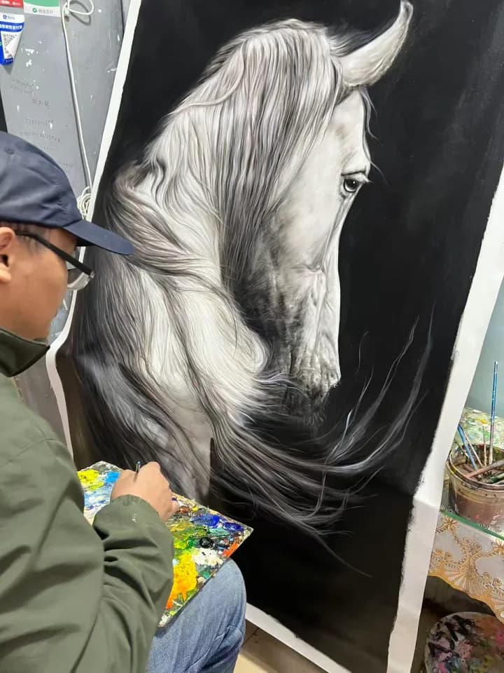 Artist refining the hair details of a monochrome horse painting
