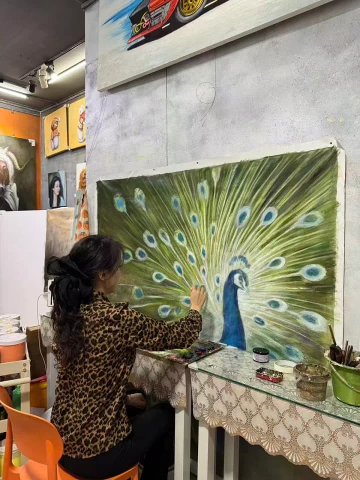 DEWANG artist hand-painting a peacock artwork in the studio