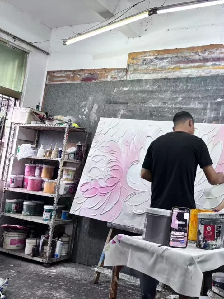 Artist applying raised texture to a large floral wall artwork