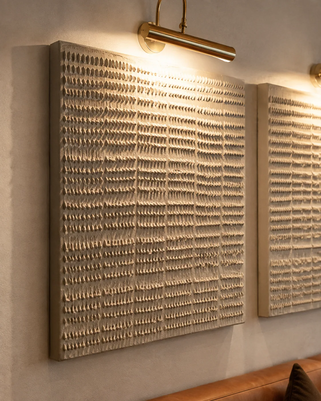 Close-up of hand-applied texture on a restaurant wall art panel under picture lighting