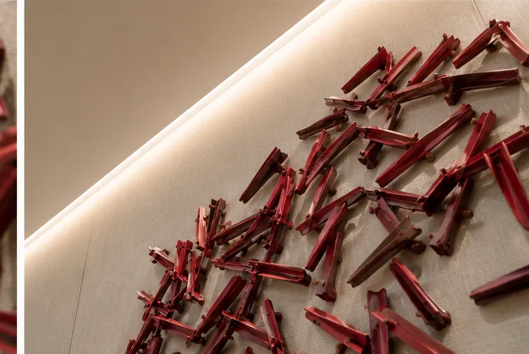 Upward angle showing the sculptural wall artwork under architectural lighting